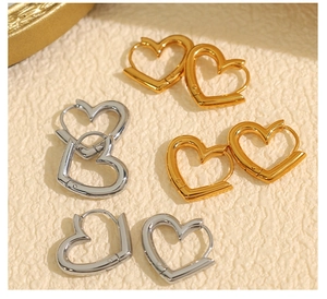 Detail of minimalist heart-shaped hoop earrings in polished gold and silver finishes