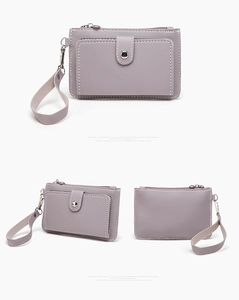 Detail view of lilac leather coin purse with white stitching and silver hardware