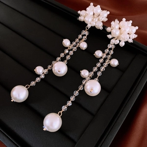 Détail des boucles d'oreilles longues à pampilles en perles sur boîte à bijoux chic