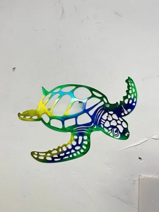 Detailed laser-cut metal sea turtle wall art with vibrant green and blue gradient finish