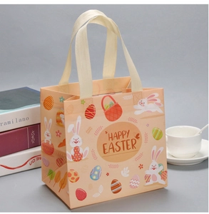 Detailed view of an orange Easter non-woven gift bag with rabbit and egg patterns