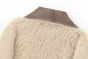 Detailopname van beige imitatiebont en donkerbruine suède kraag op de jas