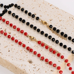 Elegant beaded necklace with faceted black and red crystals on a natural stone base