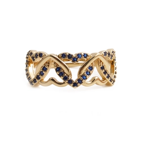 Detail of gold heart-shaped ring with micro-paved blue stones and hollow band design