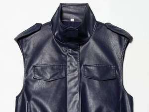 Detailed close-up of dark blue faux leather vest with shoulder straps and chest pockets