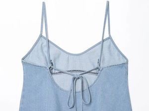 Detailaufnahme des hellblauen Denim-Tops mit dünnen Trägern und Schnürung am Rücken