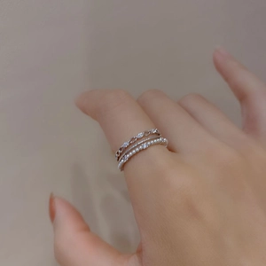 Detail of silver layered rings featuring micro-set zircon and elegant small white pearls