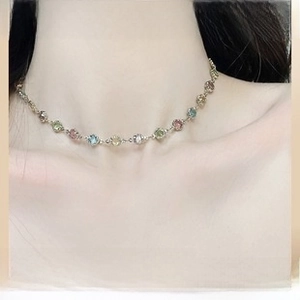 Close-up of multicolor gemstone pendant necklace worn on neck with silver metal chain