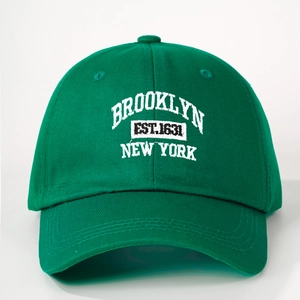 Close-up of Brooklyn New York white embroidery on a forest green cotton baseball cap