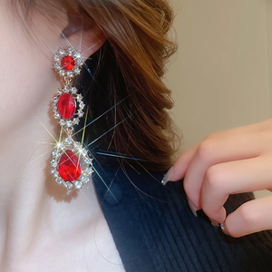 Gros plan de boucles d'oreilles pendantes en cristal rouge scintillant sur mannequin
