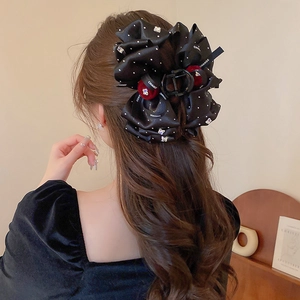 Close-up of velvet balls and rhinestone butterflies on a polka dot fabric hair claw clip