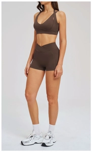 Dettaglio del set yoga marrone scuro con pantaloncini a V e reggiseno sportivo a fascia