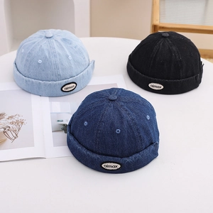 Close-up of three vintage denim dockers hats in light blue, dark blue, and black