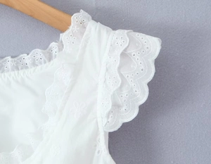 Détails de broderie anglaise blanche et dentelle ajourée sur l'épaule et la manche