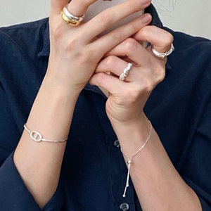 Macro view of minimalist S925 sterling silver anchor link bracelet and snake chain on wrist