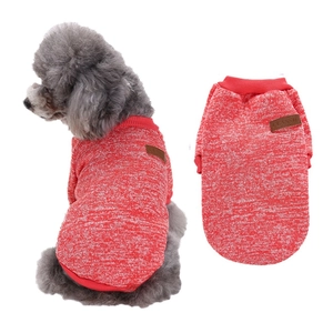 Detail of red and white knitted dog sweater with classic leather tag on white background