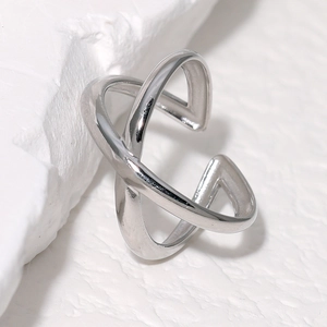 Bague ajustable en acier inoxydable argenté avec design croisé sur socle blanc