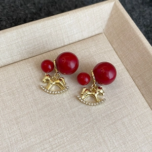 Détails de boucles d'oreilles cheval à bascule rouge avec perles et cristaux
