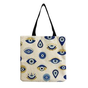Detailed view of evil eye pattern print on large canvas tote bag with black handles