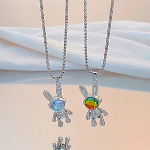 Close-up of silver long tassel necklaces with cute space rabbit pendants and blue details