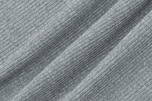 Détail macro du tissu en maille côtelée grise montrant la texture douce et élastique