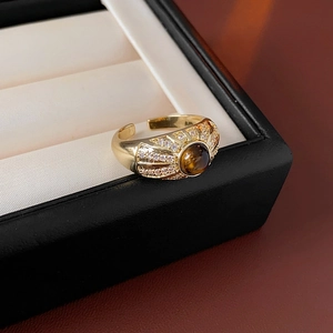 Nahaufnahme eines goldenen Vintage-Rings mit Tigerauge und Zirkonia-Verzierungen