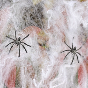 Close-up of realistic black spiders on fluffy white artificial cobweb for Halloween decor