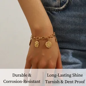 Macro view of gold-plated stainless steel chain bracelet with sun and heart charms