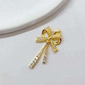 Golden bow pendant necklace with micro-pave zircons and dangling tassel charms