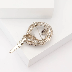 Detailed back view of silver snake brooch showing secure safety pin and dark rhinestones