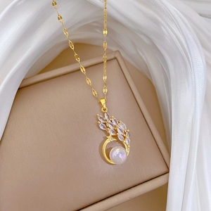 Detail of mermaid peacock necklace with crystals and pink pearl on beige jewelry box