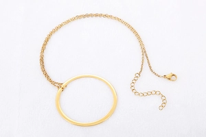 Detail of gold double-layer necklace with large hollow circular pendant and lobster clasp