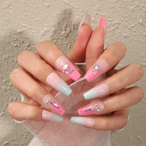 Detail of pink and blue gradient coffin press-on nails with sparkling rhinestones
