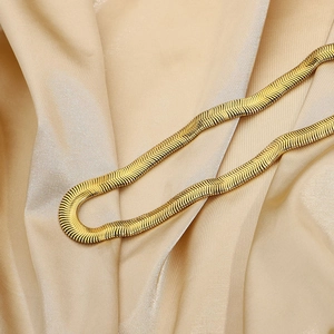Collana a catena serpente dorata in acciaio inossidabile su tessuto di seta color champagne