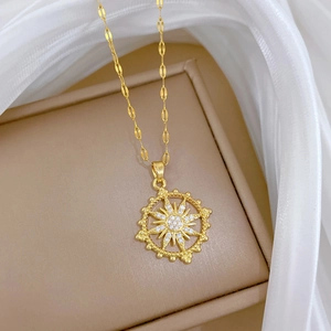 Close-up of gold sunburst necklace pendant with micro-set zircons on soft silk