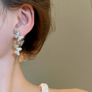 Macro shot of butterfly tassel earrings with mother of pearl and zircon stones