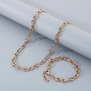 Macro shot of gold stainless steel necklace and bracelet set with S-shape infinity links