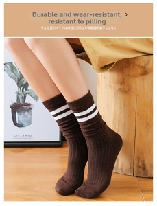Detail of dark brown ribbed cotton mid-calf socks with white stripes in varsity style