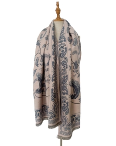 Detail of soft paisley pattern scarf with elegant fringe trim on a wooden mannequin