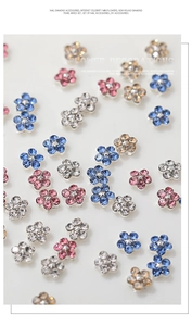 Detailed macro view of 3D metallic flower nail art gems with sparkling crystal petals