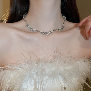 Close-up of sparkling diamond-encrusted lace geometric necklace worn by a female model