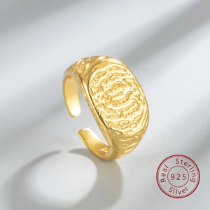Macro detail of S925 sterling silver ring with irregular fingerprint texture and gold finish