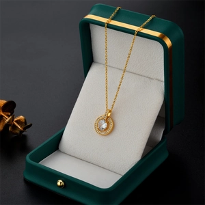 Exquisite gold circle necklace with zircon pendant displayed in a green gift jewelry box