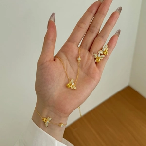 Macro detail of gold-plated silver bee jewelry set with yellow zircon stones on model