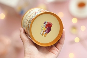 Close-up of LuLu the Piggy mini tin can in warm orange with a detailed bunny character