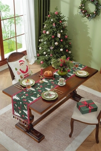 Close-up of deep green Christmas table runner with Santa patterns and red tassels