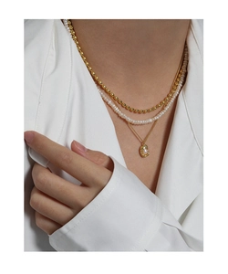 Detail of triple-layered S925 silver necklace with pearls and gold beads on a model