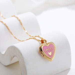 Detail showing an openable heart-shaped locket pendant in pink enamel on a golden chain