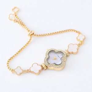 Detailed macro view of the gold clover charm bracelet watch with rhinestone bezel