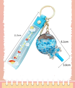 Blue unicorn keychain with floral charms and quicksand bottle pendant on a wristband